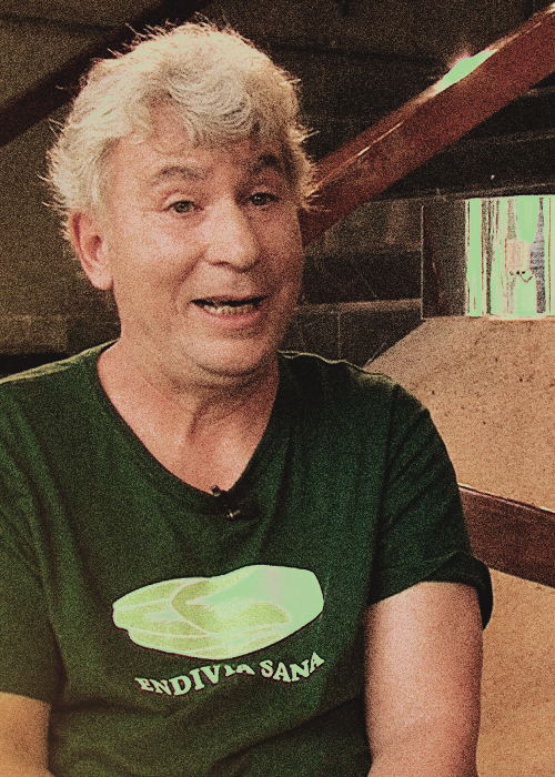 Bartolo Luque charlando, sentado y con playera verde, para la serie Pensadores Contemporáneos
